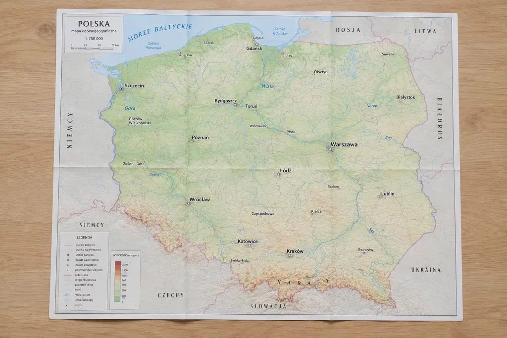  Mapa Polski z zaznaczonymi głównymi miastami i rzekami, leżąca rozłożona na jasnym stole