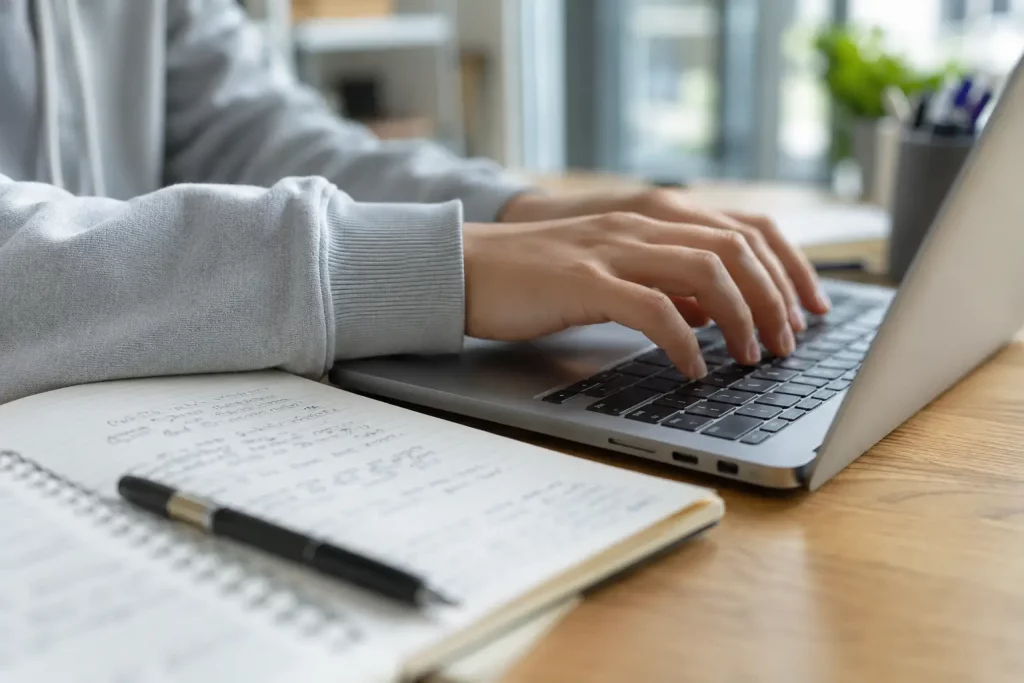 student korzystający z laptopa i aplikacji AI podczas nauki w bibliotece