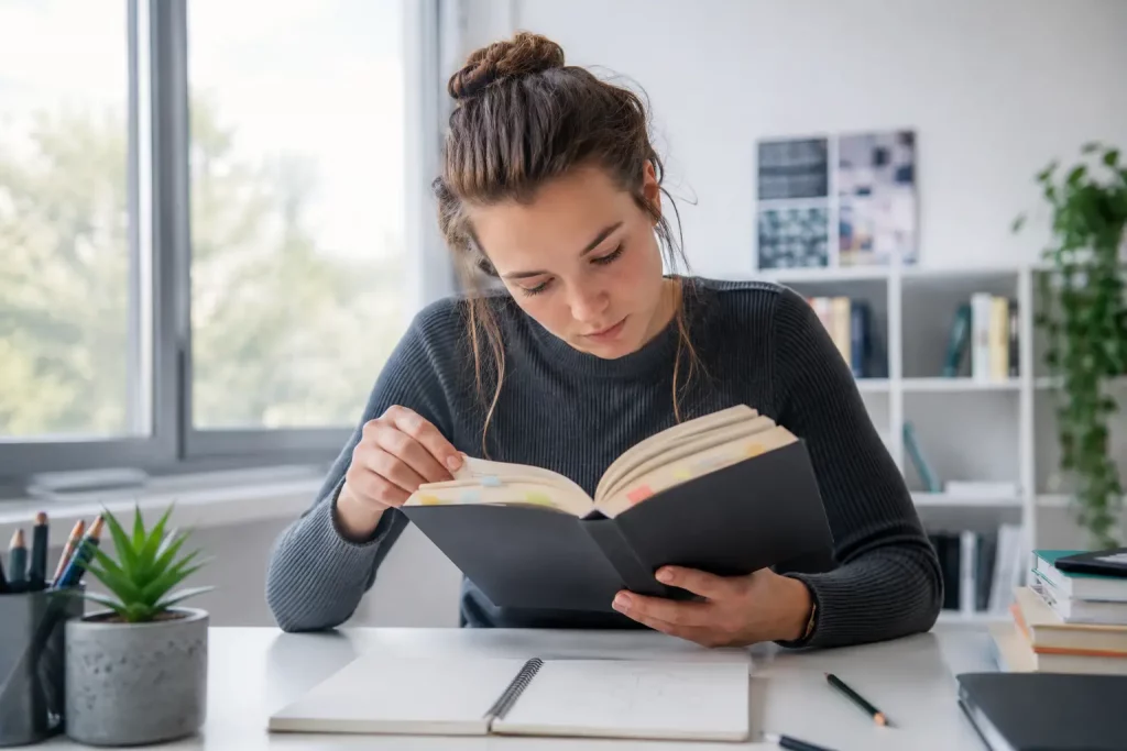 czytelnik analizujący krótką nowelę z kolorowymi zakładkami przy jasnym bibliotecznym stole